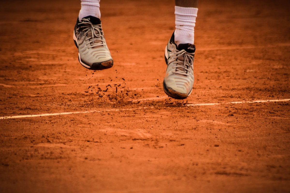 Tennis shoes on a clay court showing slide marks
