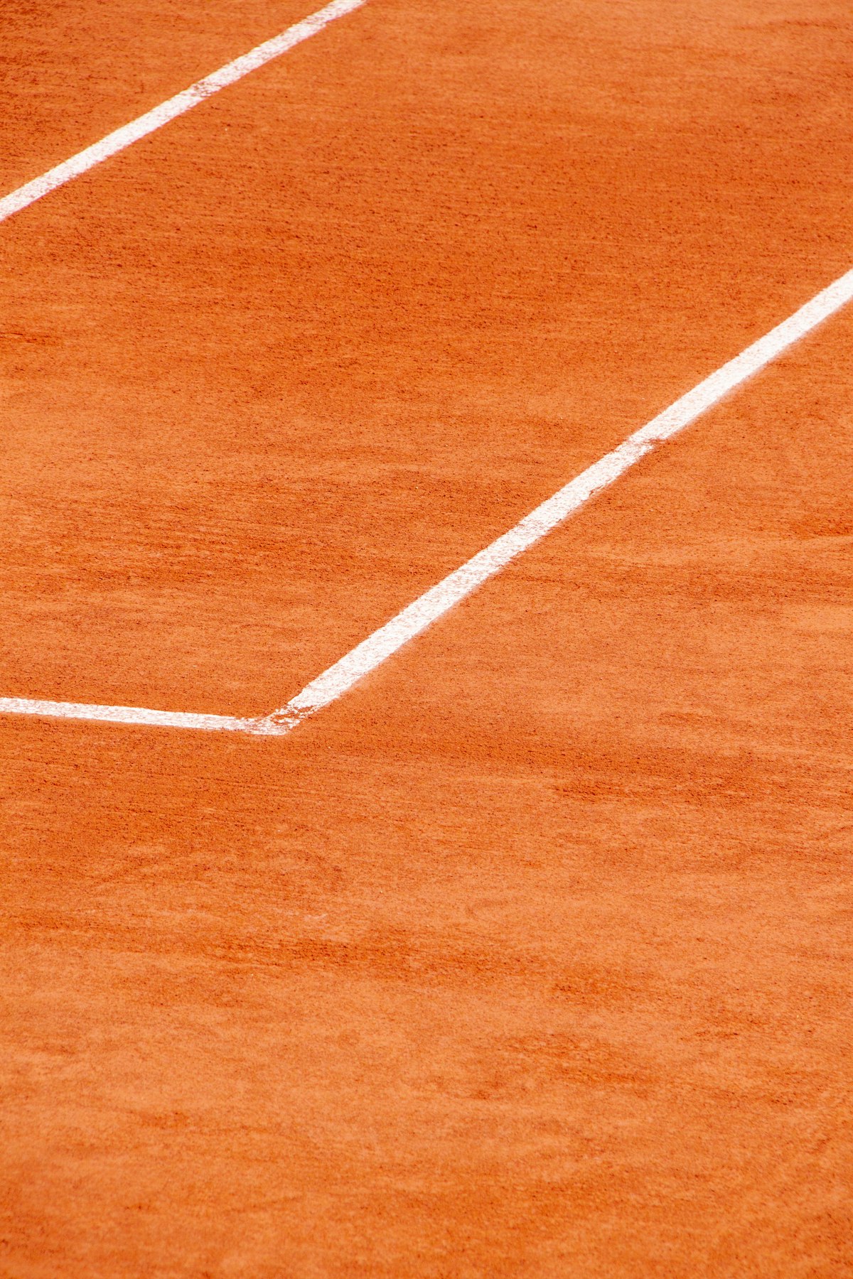 Red clay court surface with white lines