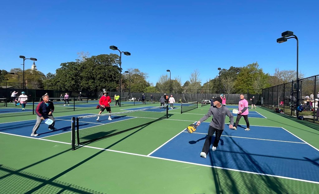 Players mid-rally on an outdoor pickleball court